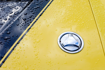 Part of the hood of the yellow muscle car