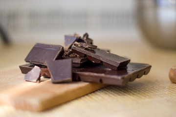 Cut chocolate pieces on the wooden background