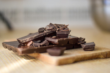 Cut chocolate pieces on the wooden background