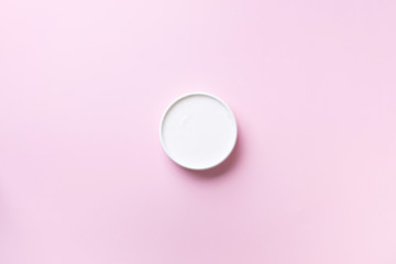 Body butter jar on pink background with copy space. Skin care product, natural cosmetic, cream concept. Top view, flat lay