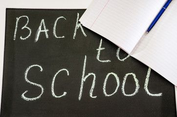 chalk inscription "back to school" on a black board. Stationery.