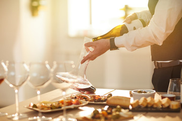 Mid section portrait of professional sommelier pouring wine while preparing for wine tasting session in sunlight, copy space - obrazy, fototapety, plakaty