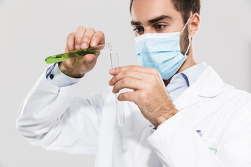 Portrait of caucasian young medical doctor working in clinic laboratory and holding test tube