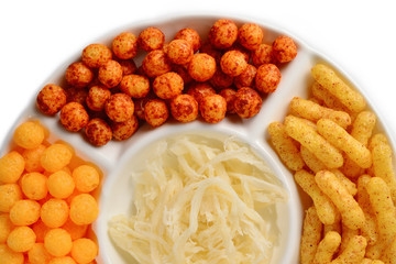 Mix of snacks on a white plate isolated on white.