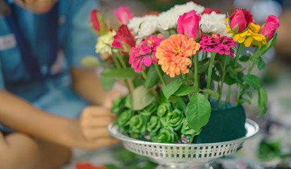 Students help each other to create a flowers tray with pedestal  for The Teachers’ Day