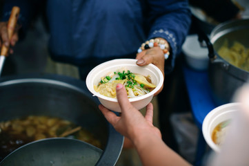 Hand-feeding to the needy in society : Concept of Feeding : Volunteers give food to the poor :...