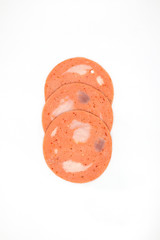 Bologna mixed with fresh chilli and pork ham, slides into a circular plate on a white background