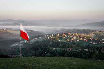 Waving Polish flag in the mountains above the village