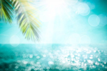 Obraz na płótnie Canvas Blurred background of sea and green palm 