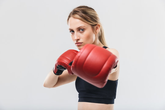 Image of european blond woman 20s dressed in sportswear and boxing gloves working out and during fitness in gym