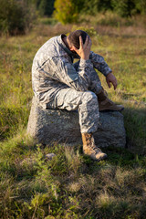 Naklejka na ściany i meble Soldier tying shoes. Soldier. Soldier in gear. The soldier sits and rests.