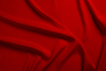 Red silk or satin luxury fabric texture can use as abstract background. Top view.