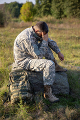 Naklejka na ściany i meble Soldier tying shoes. Soldier. Soldier in gear. The soldier sits and rests. 