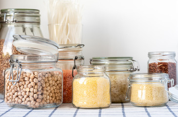 Various raw grain, cereals and legumes in glass jars for cooking healthy and vegetarian food.  Clean food, balanced diet, zero waste, plastic free