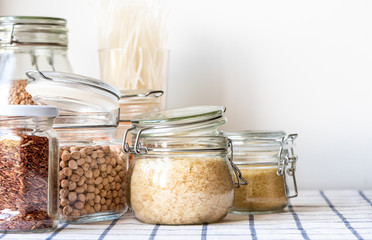 Various raw grain, cereals and legumes in glass jars for cooking healthy and vegetarian food. ...