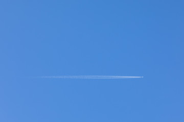 A High-resolution Image Of A Plane Flying Through The Clear Blue Sky Overhead, With A Trail Behind It. Mockup Template On The Topic Of Air Travel With Copy Space For Text.