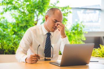Tired businessman rubbing his eyes. Office syndrome concept.