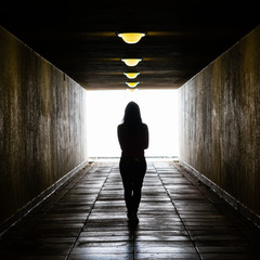 silhouette of young girls standing in the middle of a dark corridor