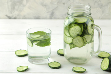 water with cucumber. Refreshing diet water with cucumber in a glass cup on a light background. detox drink concept. summer refreshing drink.