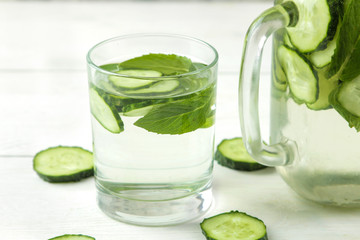 water with cucumber. Refreshing diet water with cucumber in a glass cup on a light background. detox drink concept. summer refreshing drink.