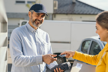 woman paying with debit card for post express service