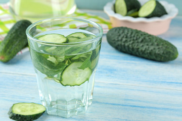 water with cucumber. Refreshing diet water with cucumber and mint in a glass beaker against a blue background. detox drink concept. summer refreshing drink.