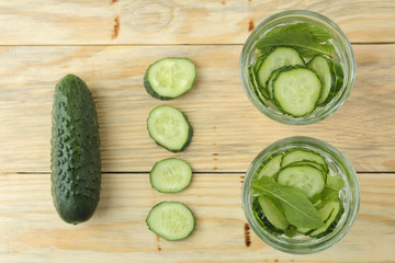 water with cucumber. Refreshing diet water with cucumber and mint in a glass beaker on a wooden...