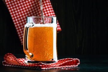 light beer in a little old-fashioned mug on old wooden table, selective focus