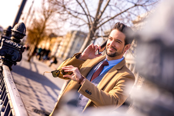 An elegant man walking and talking on his phone