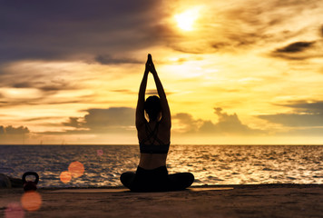 Fototapeta premium Abstrac.Silhouette yoga.Portrait of young woman practicing yoga at the sea.Relax at the sea.Meditation