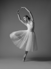 Ballerina dancing in white dress. Black and white photo.