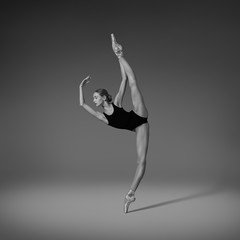  Ballerina doing vertical split. Black and white photo 