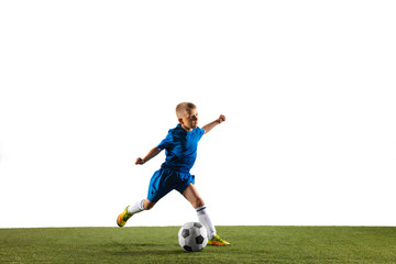 Obraz na płótnie Canvas Young boy as a soccer or football player in sportwear making a feint or a kick with the ball for a goal on white studio background. Fit playing boy in action, movement, motion at game.