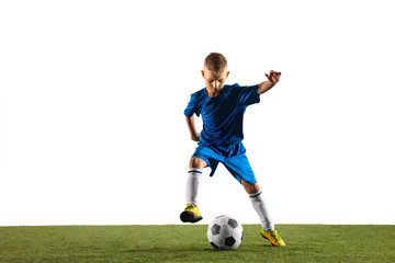 Obraz premium Young boy as a soccer or football player in sportwear making a feint or a kick with the ball for a goal on white studio background. Fit playing boy in action, movement, motion at game.