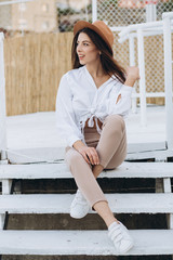 A stylish woman walks along the beachfront on a warm summer day in the sunset