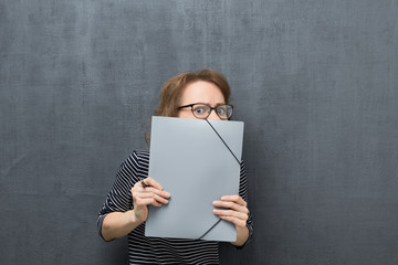 Portrait of afraid girl looking out from folder