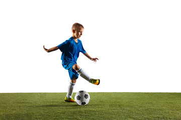Young boy as a soccer or football player in sportwear making a feint or a kick with the ball for a goal on white studio background. Fit playing boy in action, movement, motion at game.