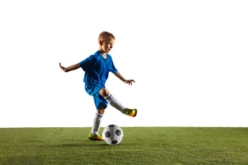 Obraz premium Young boy as a soccer or football player in sportwear making a feint or a kick with the ball for a goal on white studio background. Fit playing boy in action, movement, motion at game.