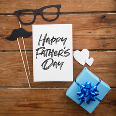 Father's day card with blue wrapped present and paper mustache