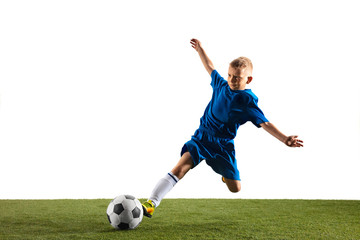 Fototapeta na wymiar Young boy as a soccer or football player in sportwear making a feint or a kick with the ball for a goal on white studio background. Fit playing boy in action, movement, motion at game.