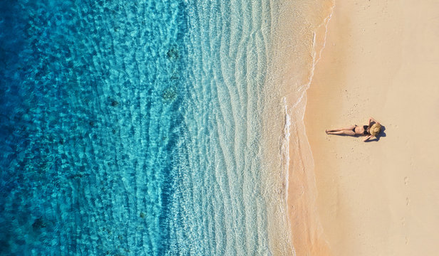 Aerial view of a girl on the beach. Vacation and adventure. Beach and turquoise water. Top view from drone at beach, azure sea and relax girl. Travel and relax - image