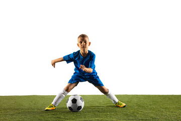 Obraz premium Young boy as a soccer or football player in sportwear making a feint or a kick with the ball for a goal on white studio background. Fit playing boy in action, movement, motion at game.