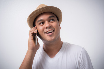 Young Asian man with hat talking on phone