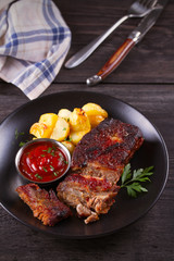 Roasted pork spare ribs with potatoes. Grilled meat. vertcal