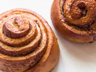 Confectionery baking. Sweet fresh soft roll bun with cinnamon on white background. Cinnabon closeup