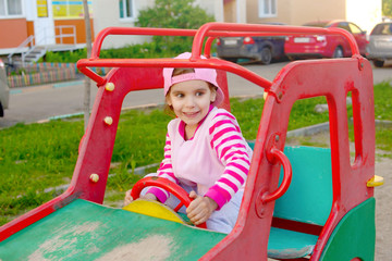 Fototapeta na wymiar Active little girl 4 years old in a pink cap on the Playground on a summer evening.
