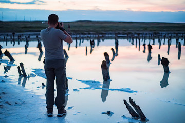Back view male outdoor photographer at salt lake Baskunchak in Russia