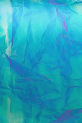 Abstract background of neon colours from crumpled gift paper and backlight