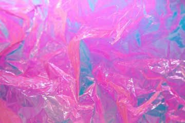 Abstract background of neon colours from crumpled gift paper and backlight