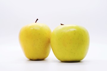 Two yellow apples on white background